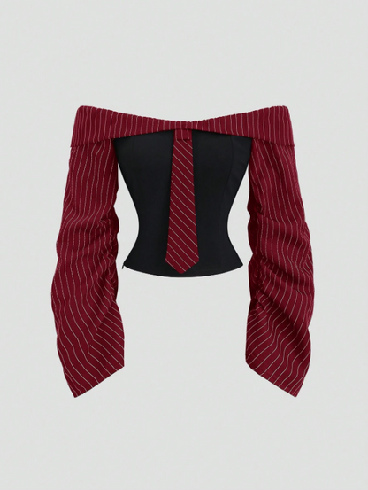 Two-tone off-shoulder black top with striped red sleeves and an attached necktie detail laid flat against a neutral background