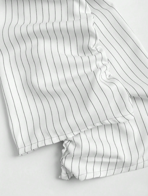 Two-tone off-shoulder black top with striped white sleeves and an attached necktie detail laid flat against a neutral background