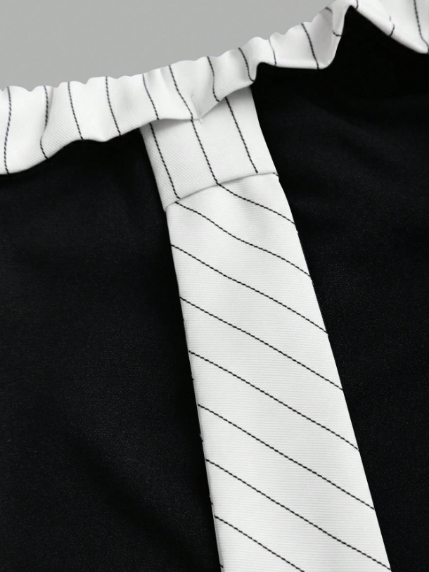 Two-tone off-shoulder black top with striped white sleeves and an attached necktie detail laid flat against a neutral background