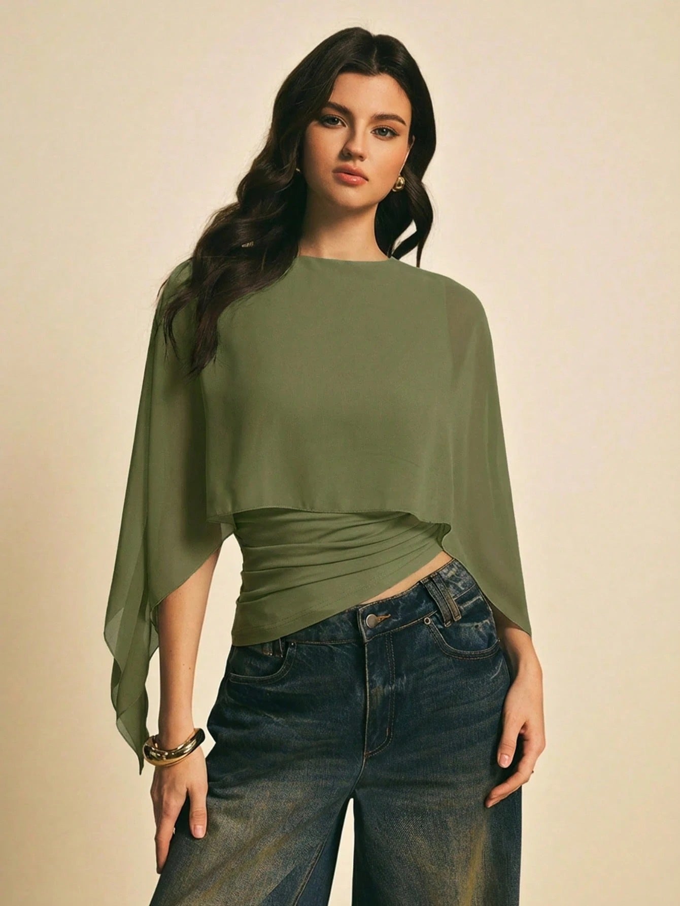 Woman wearing a Army Green solid color elegant shawl blouse with cape sleeves paired with dark denim jeans
