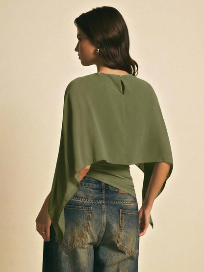Woman wearing a Army Green solid color elegant shawl blouse with cape sleeves paired with dark denim jeans