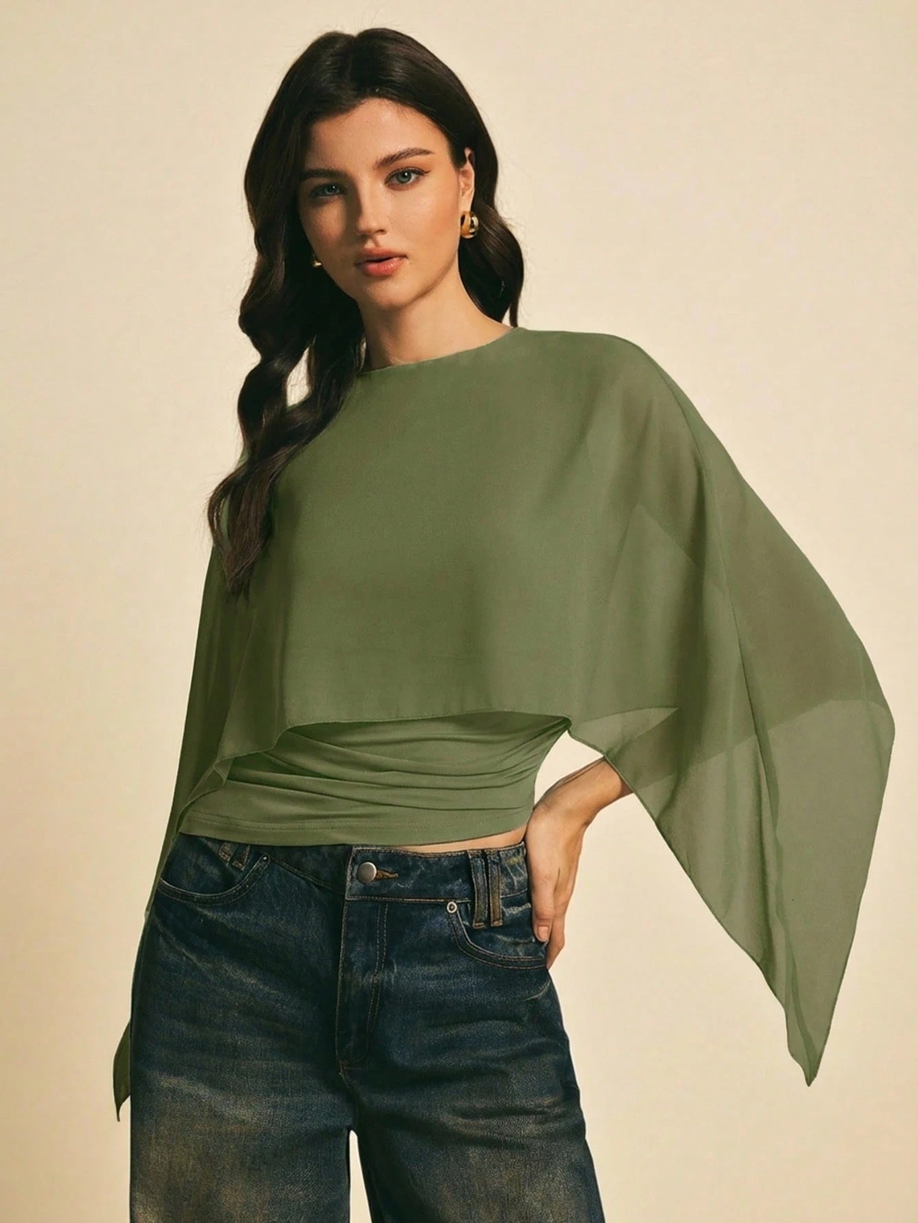 Woman wearing a Army Green solid color elegant shawl blouse with cape sleeves paired with dark denim jeans