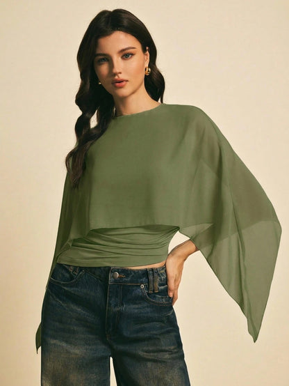 Woman wearing a Army Green solid color elegant shawl blouse with cape sleeves paired with dark denim jeans