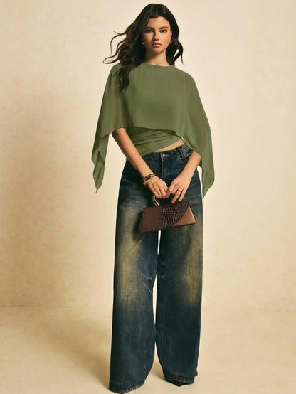 Woman wearing a Army Green solid color elegant shawl blouse with cape sleeves paired with dark denim jeans