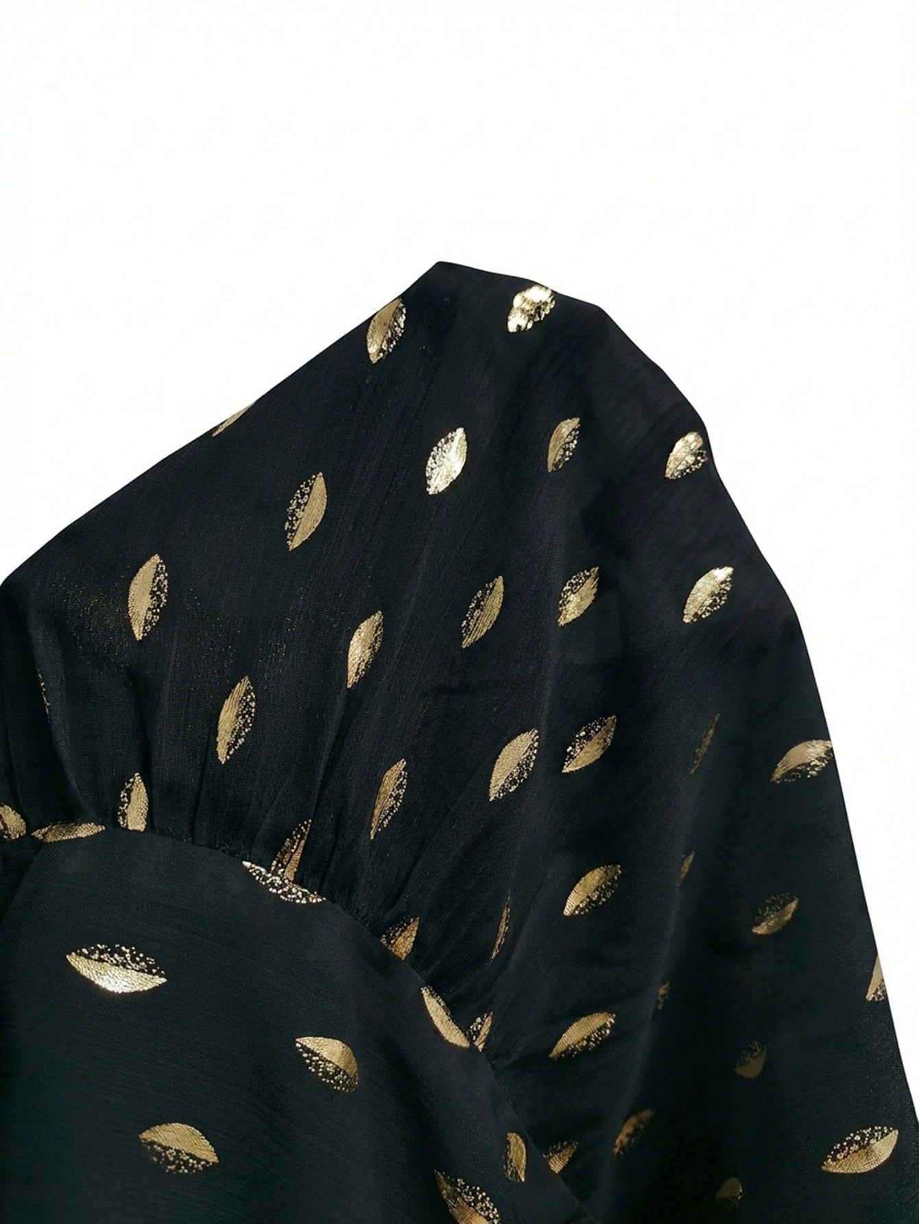 Women's black long-sleeve chiffon blouse with metallic foil dots, a V-neck, a scarf tie, and a tiered ruffled hem paired with blue jeans.