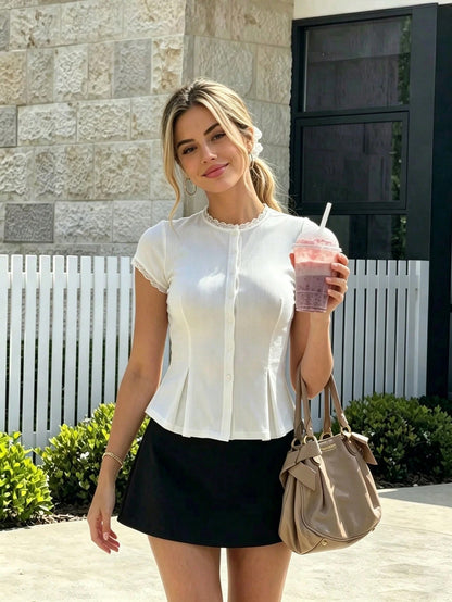 Women's cute ribbed knit lace-trim cap sleeve button-front peplum top in white paired with a black skirt.