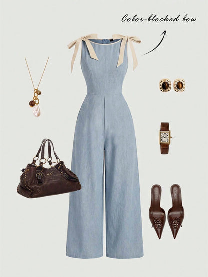 blue wide-leg sleeveless jumpsuit featuring contrast brown shoulder bow ties and trim laid flat against a neutral background