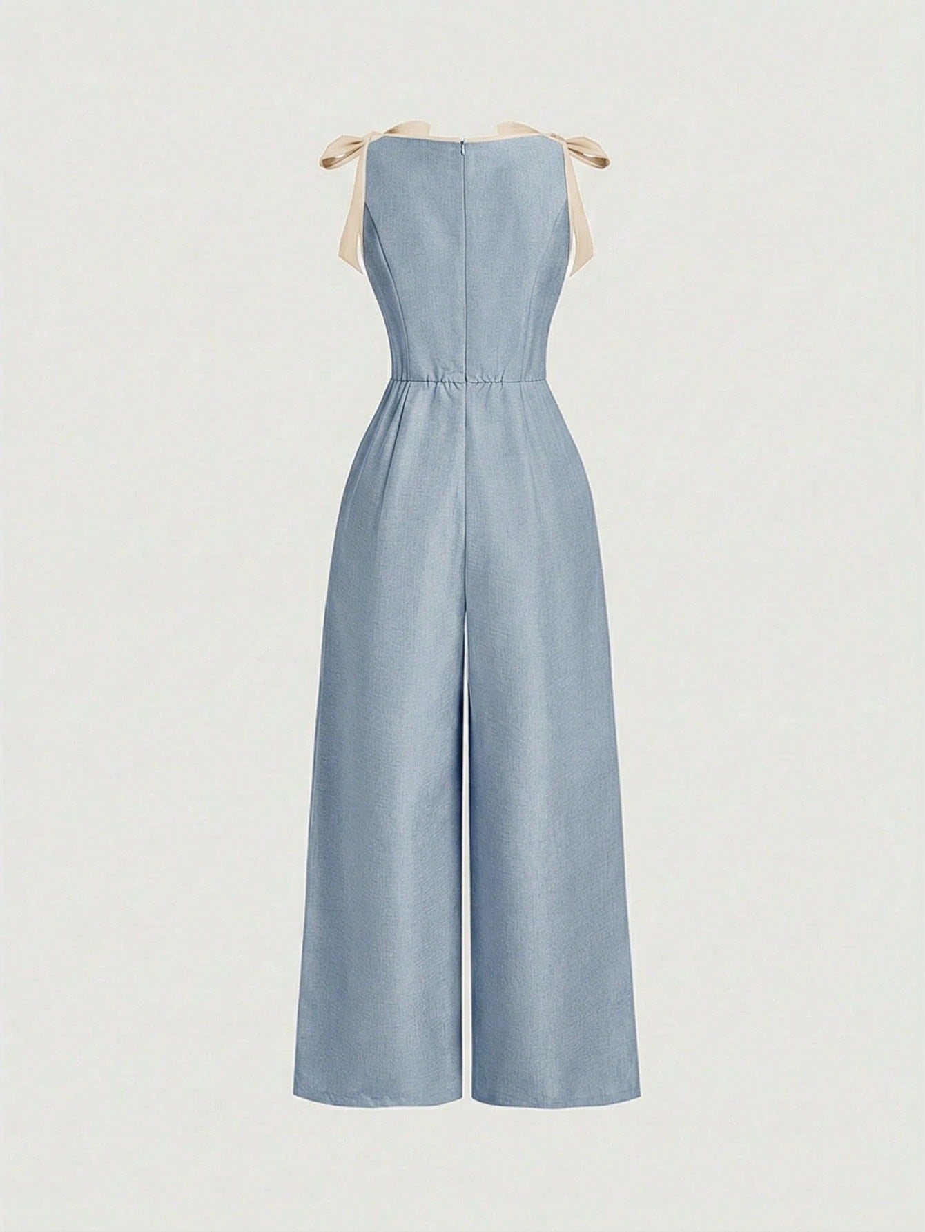 blue wide-leg sleeveless jumpsuit featuring contrast brown shoulder bow ties and trim laid flat against a neutral background