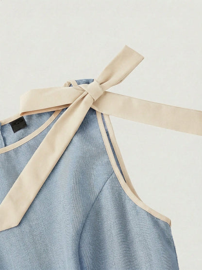 blue wide-leg sleeveless jumpsuit featuring contrast brown shoulder bow ties and trim laid flat against a neutral background